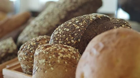 Fresh bread rolls and loaves on display in bakery shop Stock Footage 334908656