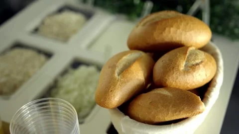 Fresh Bread Rolls Arranged in Basket on Catering Counter With Buffet Food Stock Footage 336392464