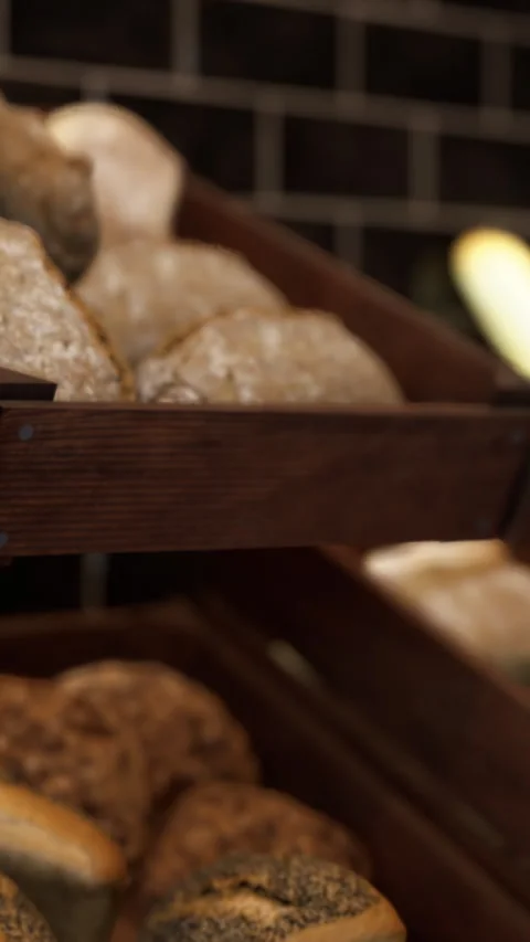 Fresh bread rolls displayed in a wooden tray at a bakery shop Stock Footage 339101909