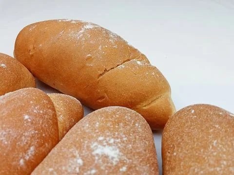 Fresh bread rolls with flour on white background Stock Photos