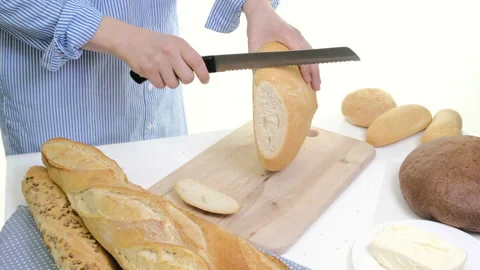 Fresh bread slice and cutting knife on rustic table. With wooman hands Stock Footage 88539267