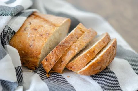 Fresh bread slice and cutting knife on wooden table Stock Photos