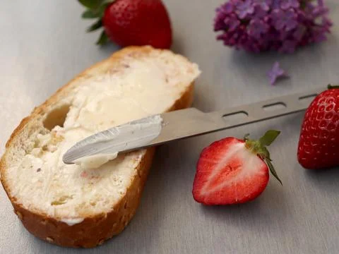 Fresh bread slice with cream spread and strawberries on a wooden table in Foto stock