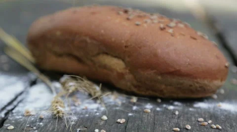 Fresh bread on the table. Hand puts bread on the table outside. Stock Footage 67380800