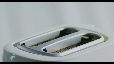 Fresh bread toasts are cooked in a toaster on bright background, cooking Video stock 118656633