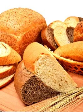 Fresh bread, wheat ears and bread slices on the wooden board Stock Photos