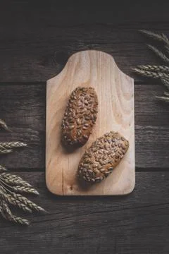 Fresh bread with wheat ears on wooden background. Stock Photos