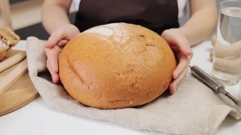 Fresh bread on a wooden table. Closeup of organic bakery goods. Whole wheat loaf Stock Footage 293281539