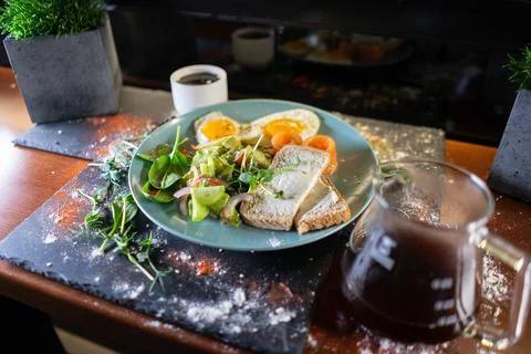 Fresh breakfast with fried eggs, bread, avocado, red fish salmon and coffee Stock Photos