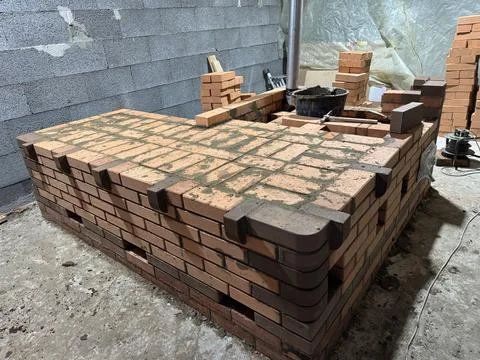 Fresh brickwork of a heating stove bench with decorative elements. Oblique An Foto stock