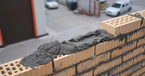 Fresh brickwork, worker continues to lay bricks, builds cottage, building house Stock Footage 116794110