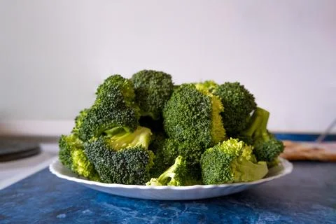 Fresh broccoli in a flat plate on the table. Preparing broccoli for dinner. Stock Photos
