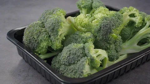 Fresh broccoli florets arranged in a black tray on a kitchen counter Stock Footage 348190832
