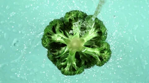 Fresh broccoli florets being washed with clean water against light blue bac.. Stock Footage 327587847