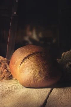 Fresh brown bread on a table in a warm kitchen Stock Photos