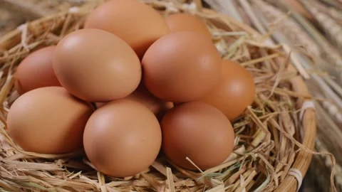 Fresh Brown Eggs Nestled in Straw Lined Rustic Wicker Basket Video stock 336546192
