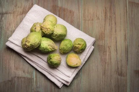 Fresh brussel sprouts over rustic wooden texture. Top view with copy space. Stock Photos