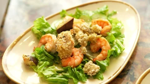 Fresh Caesar salad with grilled shrimps on a beige plate Stock Footage 335471735