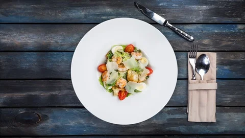 Fresh caesar salad rotating on white plate with parmesan cheese and shrimps. Is Stock Footage 129185878
