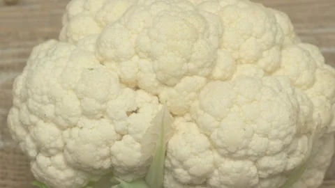 A Fresh Cauliflower Head on a Rustic Background, Highlighting Its Natural Beauty Video stock 285040553