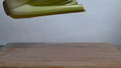 Fresh Celery falling on chopping board in slow motion Stock Footage 100007933
