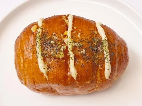 Fresh cheese bread roll with an herb topping and a golden-brown crust. Stock Photos