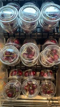 Fresh Cherries in Clear Plastic Containers on Display at a Market. Stock Photos