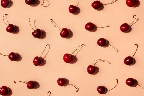 Fresh cherries pattern layout scattered on trendy beige background. Summer Stock Photos