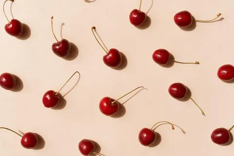 Fresh cherries pattern layout scattered on trendy beige background. Summer Stock Photos
