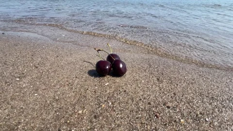 Fresh Cherries on Sandy Beach with Gentle Sea Waves in Summer Sunlight Stock Footage 340517502