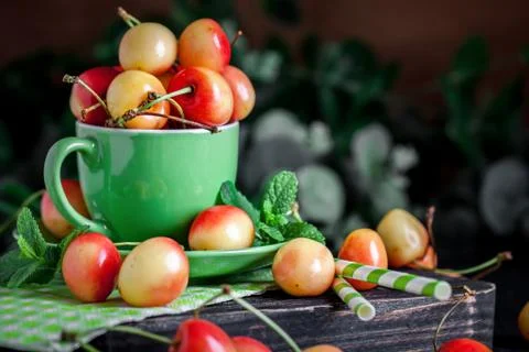 Fresh cherry in a Cup on a dark rustic wooden table. Background with space for Stock Photos