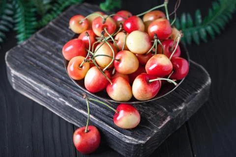 Fresh cherry in a Cup on a dark rustic wooden table. Background with space for Stock Photos