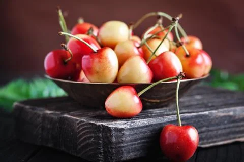 Fresh cherry in a Cup on a dark rustic wooden table. Background with space for Stock Photos