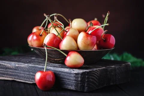 Fresh cherry in a Cup on a dark rustic wooden table. Background with space for Stock Photos