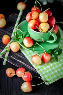 Fresh cherry in a Cup on a dark rustic wooden table. Background with space for Stock Photos