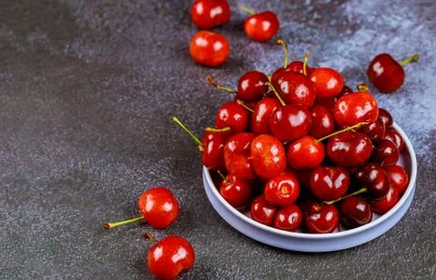 Fresh cherry on plate on dark background. Stock Photos