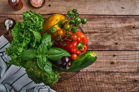 Fresh cherry tomato branches, basil leaves, napkin, pepper and pepper mill on Stock Photos