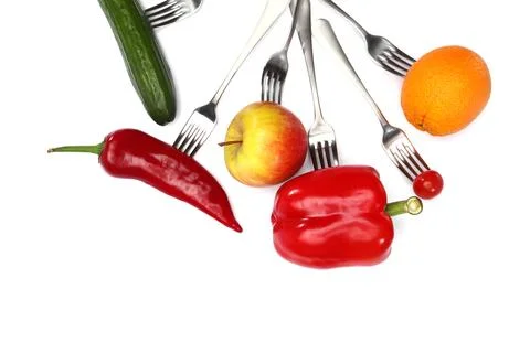 Fresh cherry tomato, red pepper, cucumber, apple and orange fruits on forks.. Stock Photos