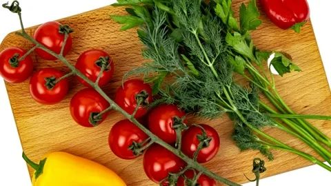 Fresh cherry tomatoes and mixed herbs on wooden cutting board Stock Footage 348237678