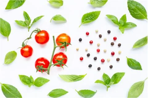 Fresh cherry tomatoes with basil leaves and different type of peppercorns on  Stock Photos