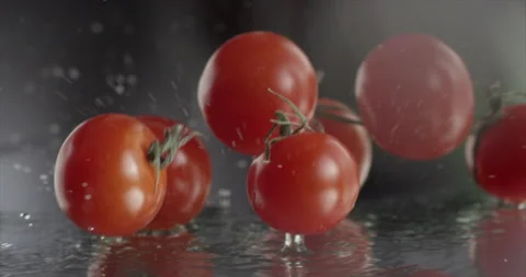 Fresh cherry tomatoes fall on a mirror surface with water Stock Footage 197042259