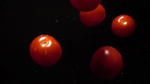 Fresh cherry tomatoes falling on a black background in slow motion 100 frames Stock Footage 254519966