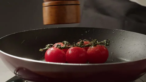 Fresh cherry tomatoes in a frying pan with olive oil and spices. Cooking tomato Vidéo 243670147