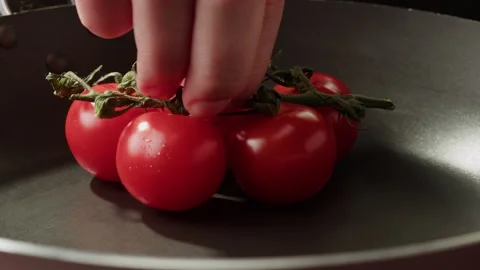 Fresh cherry tomatoes in a frying pan with olive oil and spices. Cooking tomato Stock Footage 258370828