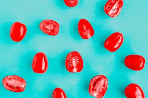 Fresh cherry tomatoes pattern on bright blue background, minimal concept Stock Photos