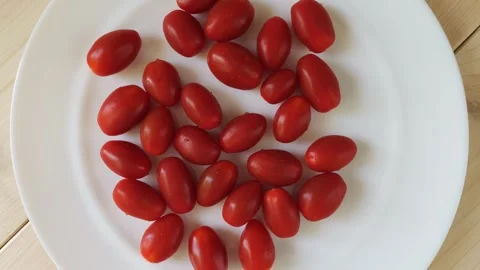 Fresh cherry tomatoes rotating on white plate Stock Footage 348309742