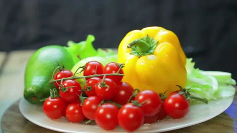 Fresh cherry tomatoes, saolat, pepper and avocado in a plate rotates in a circle Stock Footage 120415017