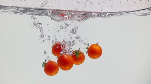 Fresh cherry tomatoes splashing into water Stock Footage 305848451