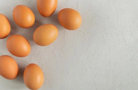 Fresh chicken eggs on a grey surface. Stock Photos