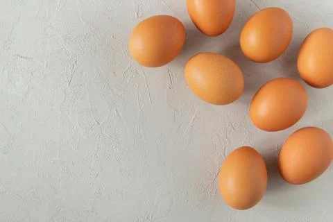 Fresh chicken eggs on a grey surface. Stock Photos